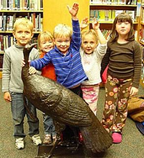 Group of kids at library with Peter France's bronze sculpture of a turkey